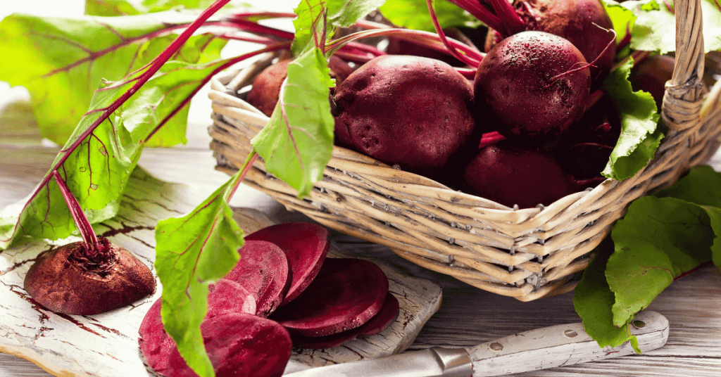 Fresh organic beets with leaves in a basket on a white background