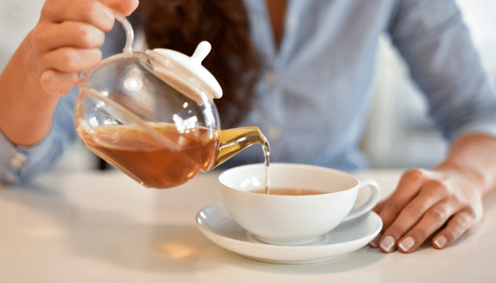 image of someone pouring a cup of steeped tea