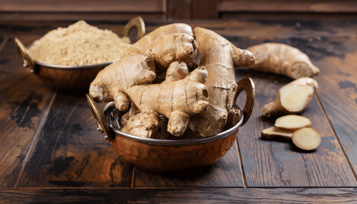 Natural remedies for upset stomach bowl of ginger root on wooden table
