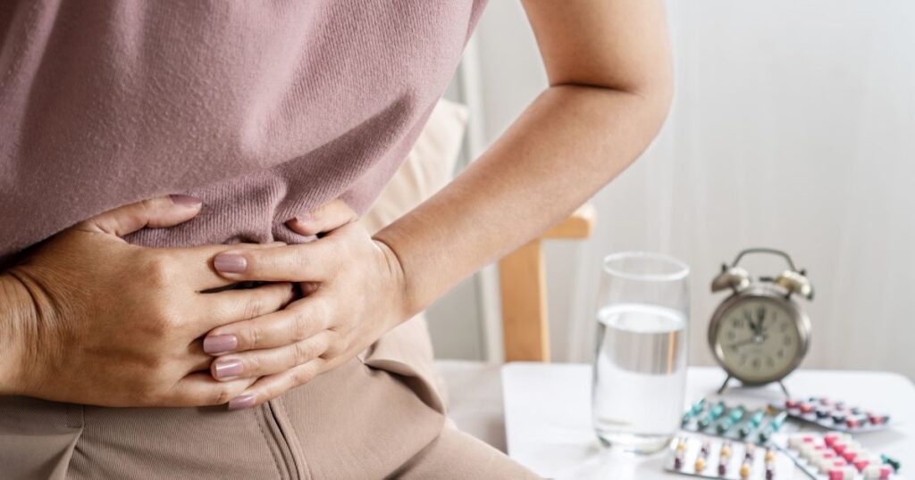 irritable bowel syndrome IBS concept with woman hand holding a stomachache having problems with the digestive system like diarrhea and constipation