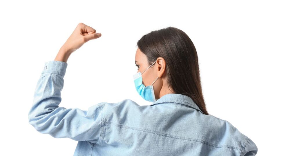 Strong Young Woman in Medical Mask on White Background, Back View. Immunity Concept